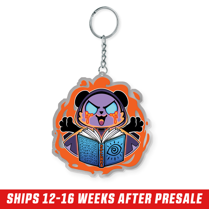 Purple cartoon bear with glowing blue eyes and orange tears holding a blue book surrounded by an orange flame design keychain